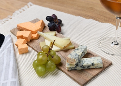 Tabla de quesos con uvas y vino para degustación